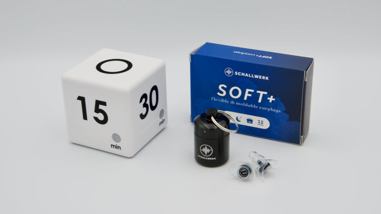 Fokus-Set im Querformat mit weißem Würfel-Timer, Schallwerk SOFT+ Gehörschutz-Stöpseln und schwarzer Aluminium-Aufbewahrungsdose