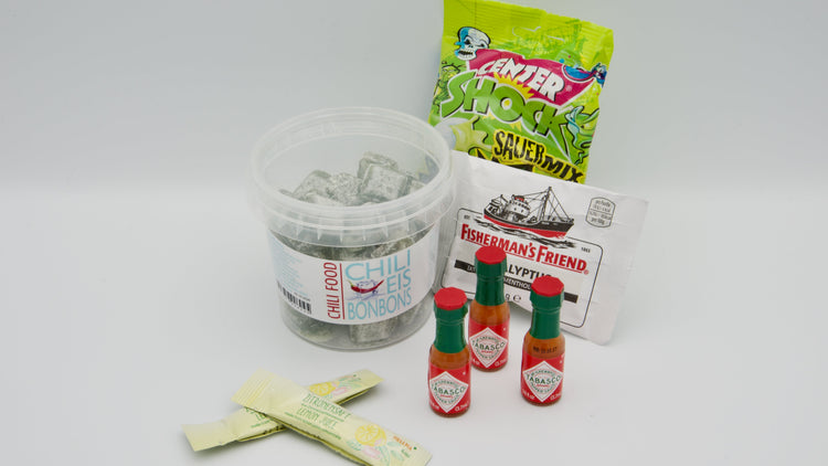 Sinnes- und Geschmacksskills im Querformat: Scharfe Chili-Eis-Bonbons, saure Kaugummis, Fisherman's Friend, Tabasco-Miniflaschen und Zitronensaft-Portionen