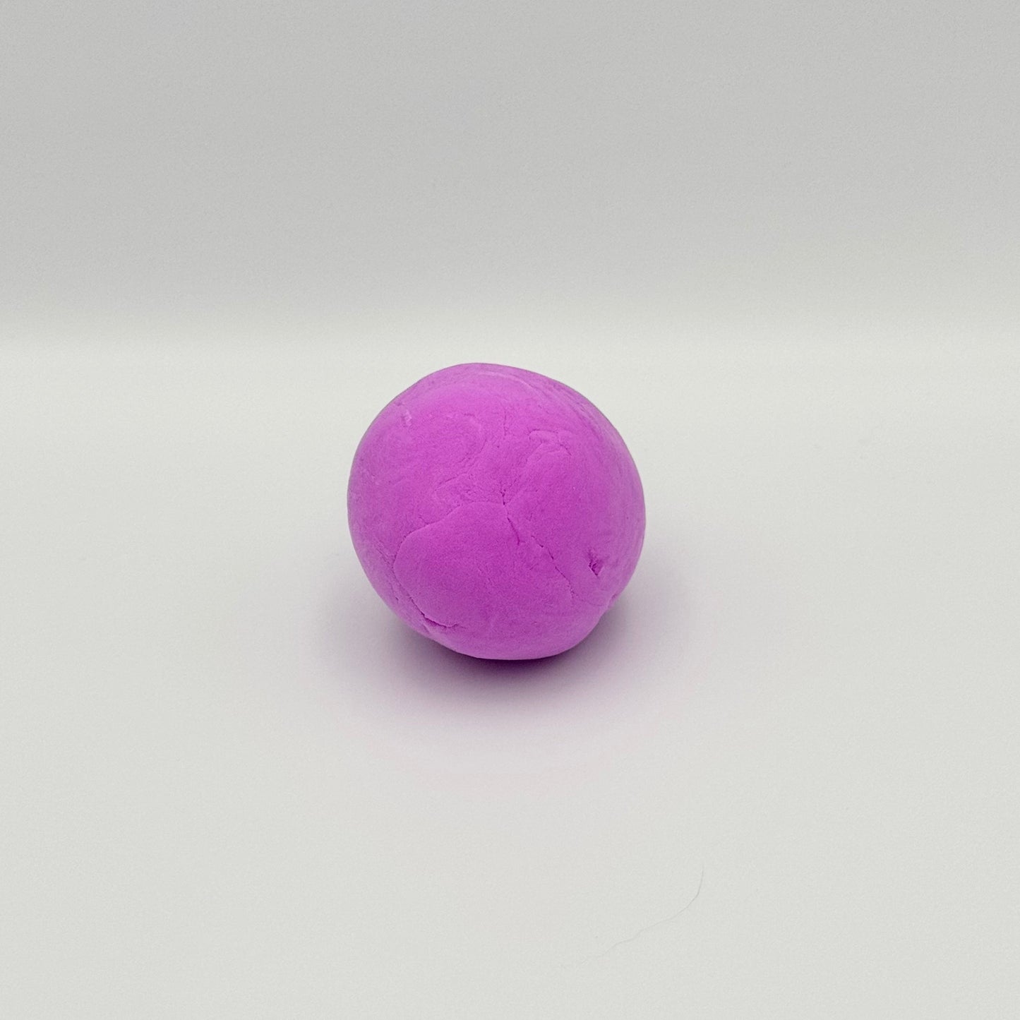 Geformte Kugel aus lila Bouncing Putty Springknete – Elastische Hüpfknete zum Kneten
