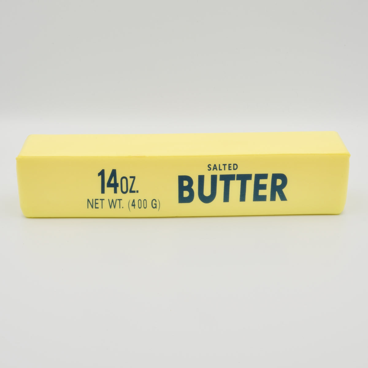 Gelber Squeeze-Riegel in Butter-Form mit der Aufschrift „14oz Salted Butter“, Frontalansicht