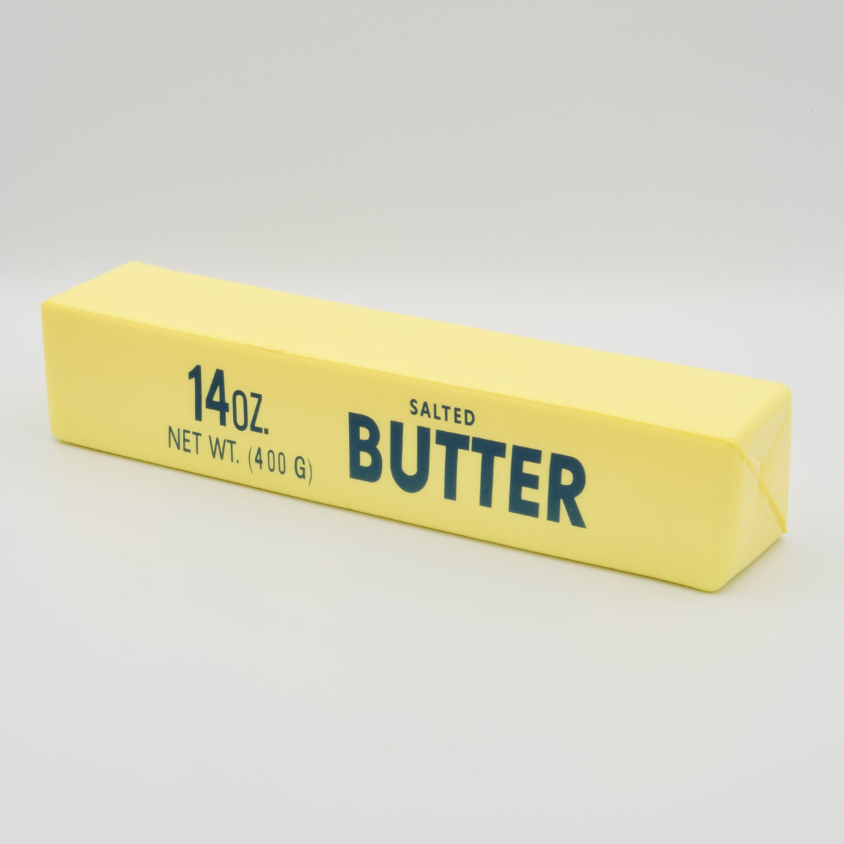 Gelber Antistress-Knetriegel in Butter-Optik mit Aufdruck „Salted Butter“, schräge Seitenansicht