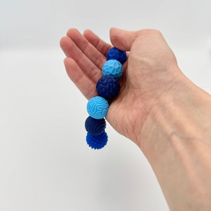 Blaue Fidgnetics Magnetkugeln mit Struktur in der Hand – magnetisches Fidget Toy