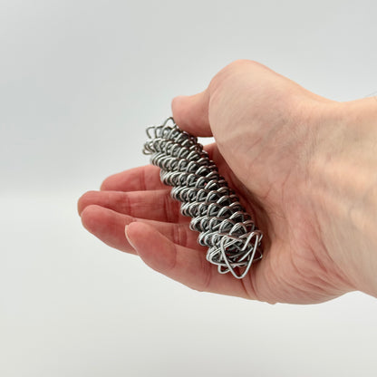 Silberne Handmassagerolle in der Hand gehalten – Akupressur Federrolle gegen Stress