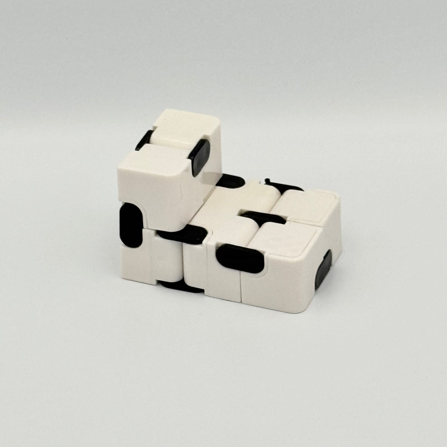 Weiß-schwarzer Infinity Cube Fidget Cube aufgefaltet – Unendlicher Klappwürfel für Hände
