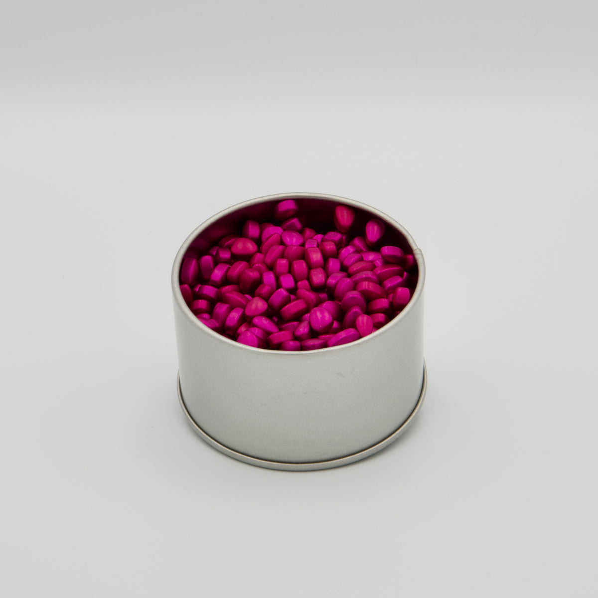 Offene, runde Metalldose, gefüllt mit pinken, magnetischen Fidget-Pellets