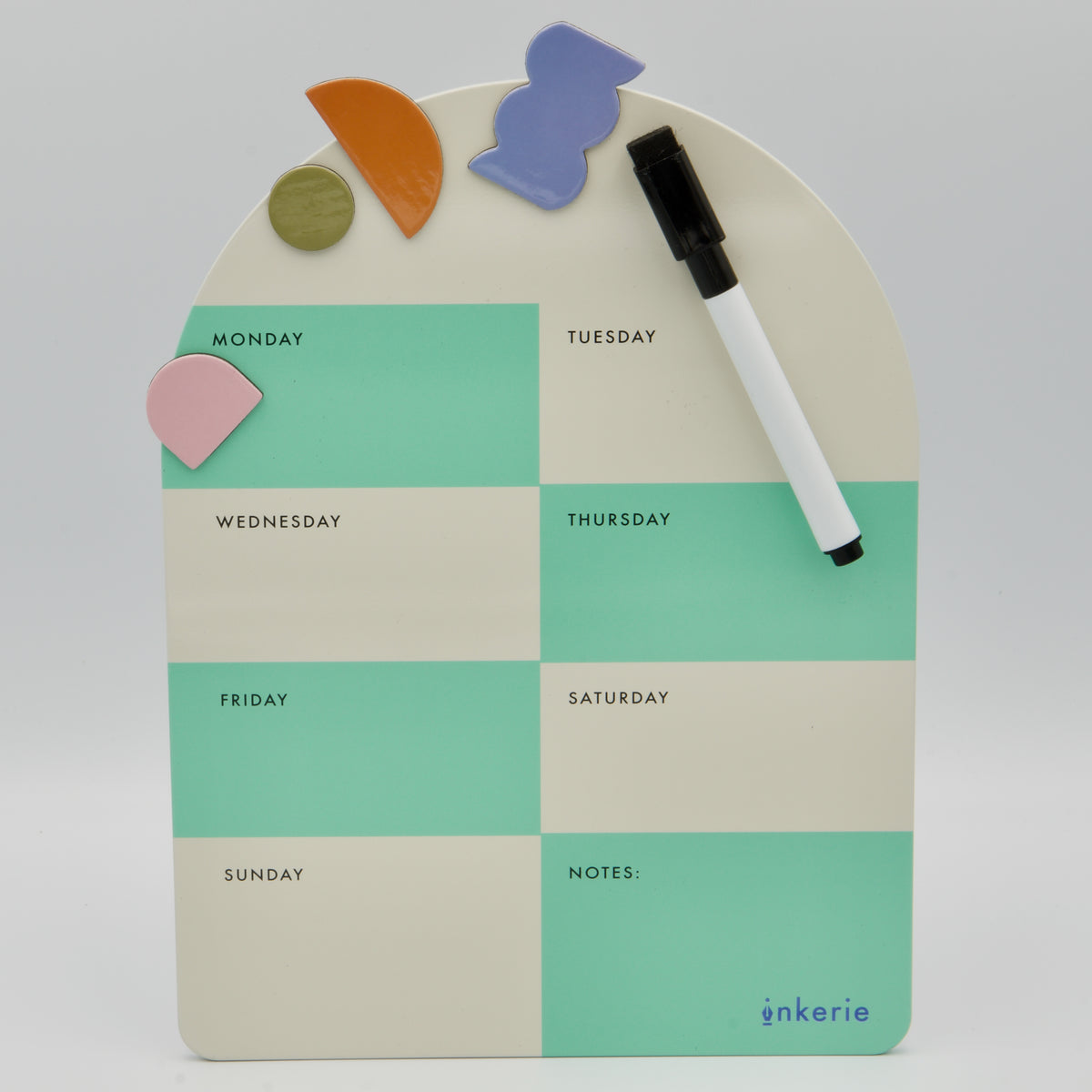 Bogenförmiger magnetischer Wochenplaner von inkerie in Mintgrün und Beige mit Wochentagfeldern, Stift und bunten Formmagneten.