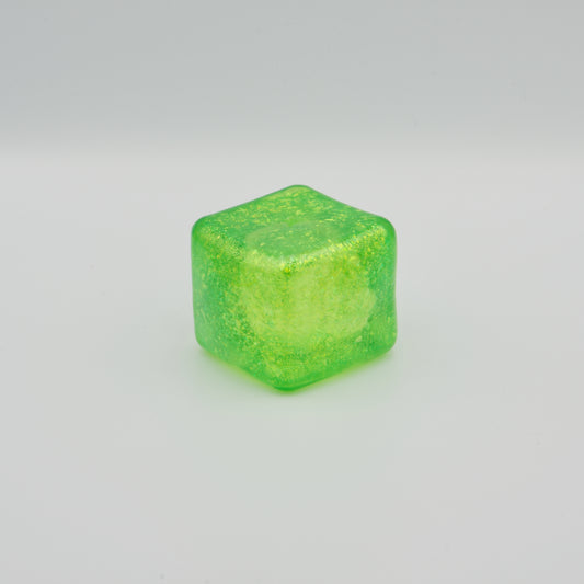 Transparenter, grüner Squeeze-Würfel mit feinen Glitzerpartikeln