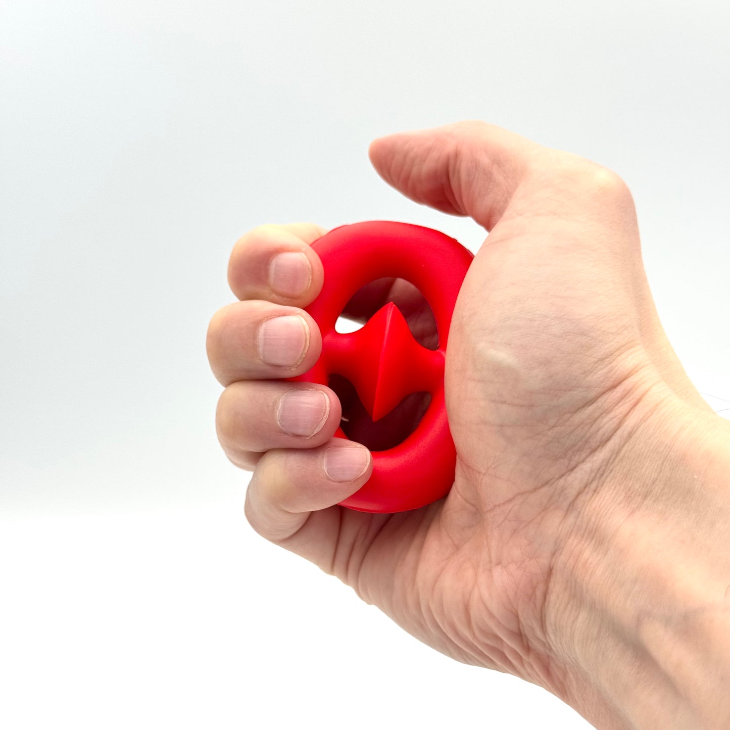 Roter Pop Snapper Saugnapf-Ring wird in der Hand gedrückt