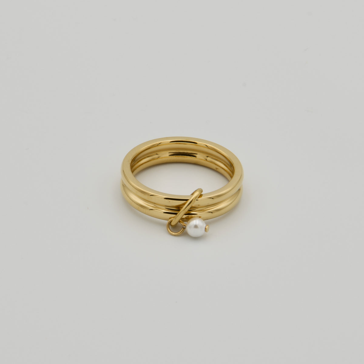 Goldfarbener Fidget-Schmuckring aus mehrreihigen Schienen mit einem kleinen, beweglichen Perlenanhänger