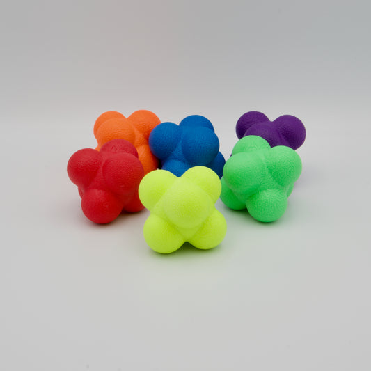 Sechs bunte Reaktionsbälle mit mehrhöckeriger Form in Rot, Orange, Blau, Gelb, Grün und Violett auf hellem Untergrund.