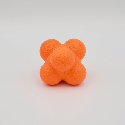 Einzelner orangefarbener Reaktionsball mit unregelmäßigen Höckern und haptischer Oberflächenstruktur.