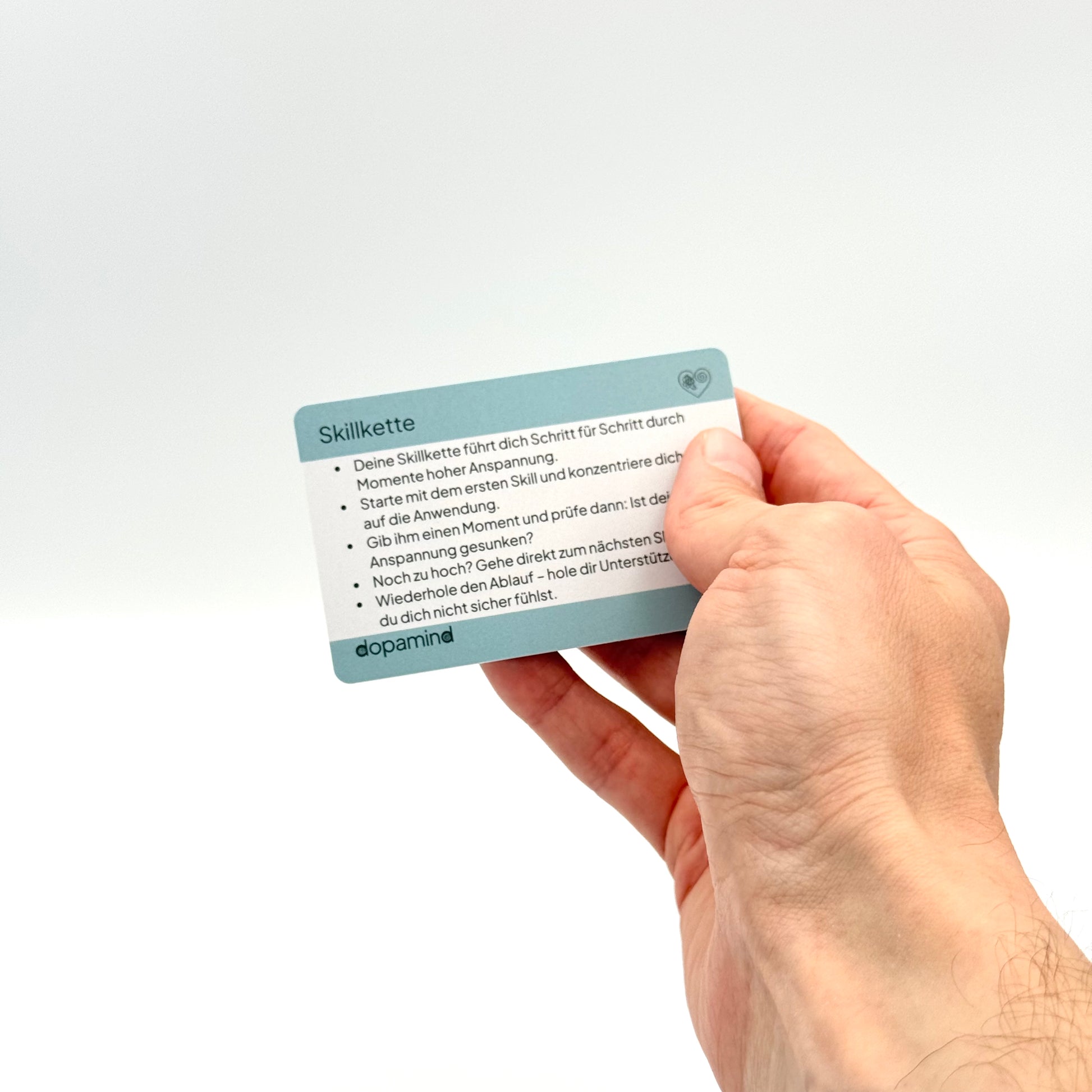 dopamind Skillkette Karte Vorderseite mit Anleitungstext in der Hand – Notfallkarte für Reizregulation