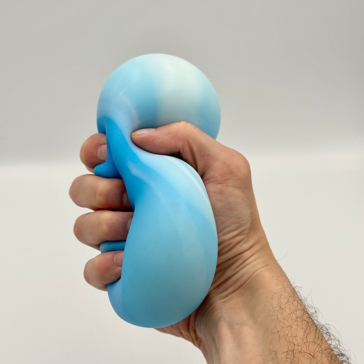 Blauer Squeeze Ball wird fest in der Hand gedrückt – Elastischer Anti-Stressball