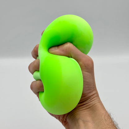 Neongrüner Squeeze Ball wird fest in der Hand gedrückt – Elastischer Anti-Stressball
