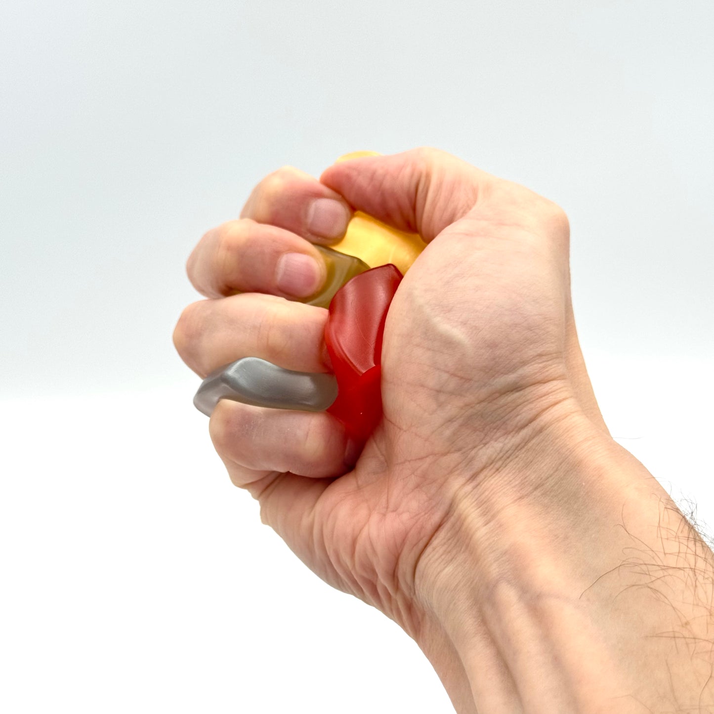 Faust drückt mehrere bunte Mini Squish Cubes – Fidget Toy für Haptik & Fokus