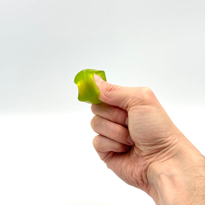 Grüner Mini Squish Cube Fidget Würfel wird mit Fingern gedrückt 