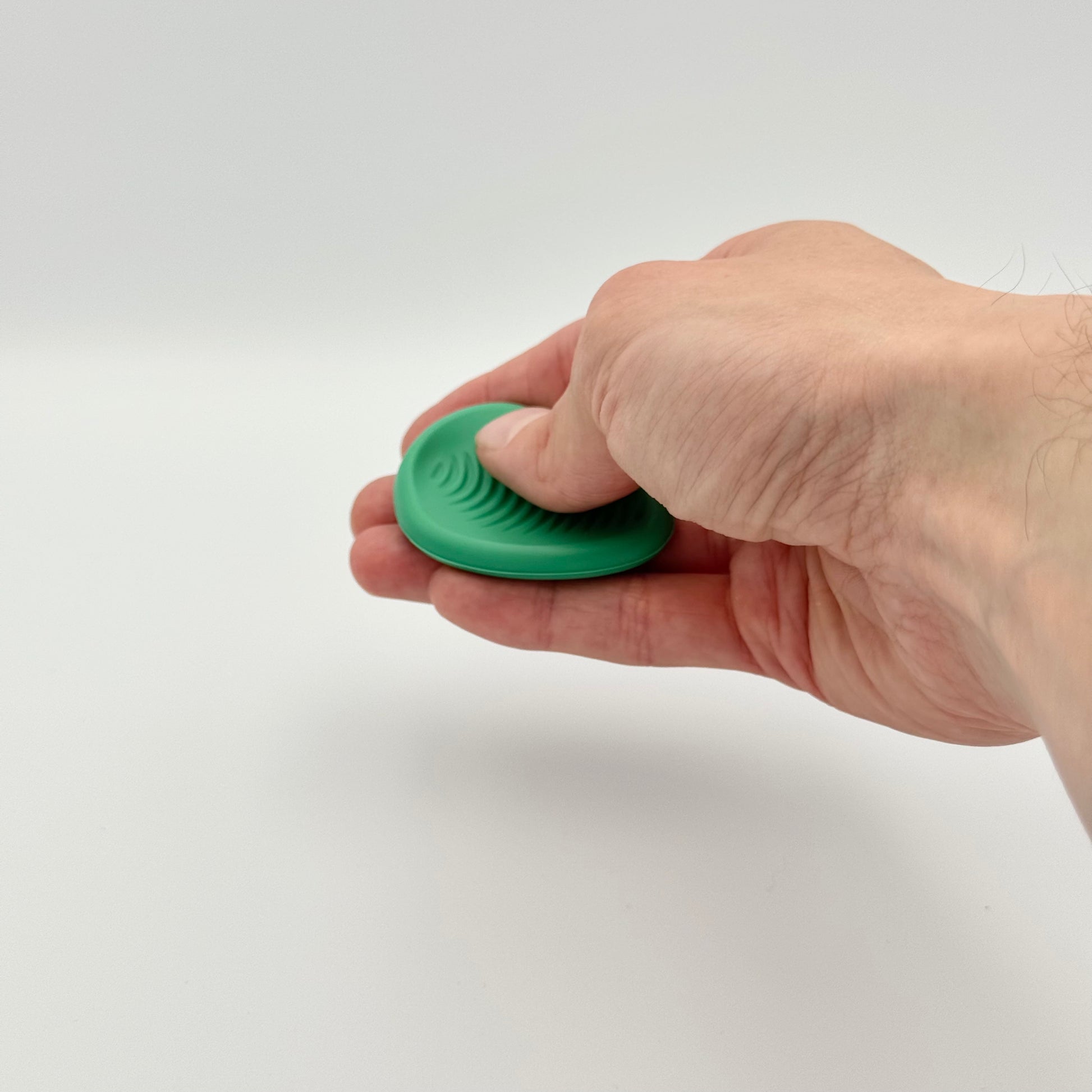 Grüner Worry Stone aus Silikon in der Hand – Sorgenstein mit Rillen für Stressabbau und Fokussierung